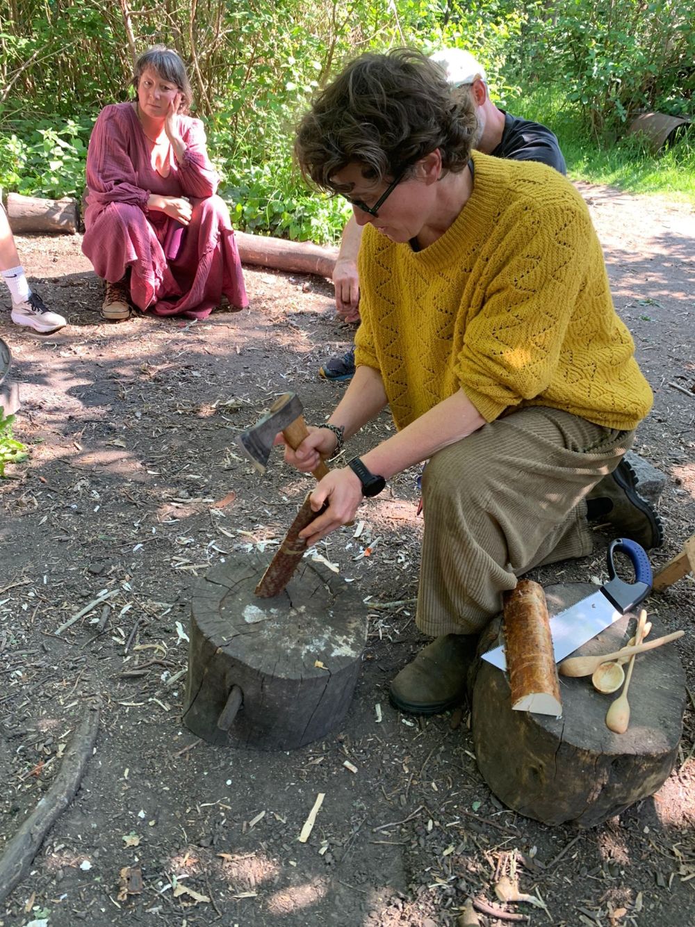 Holly showing a small group how to split wood